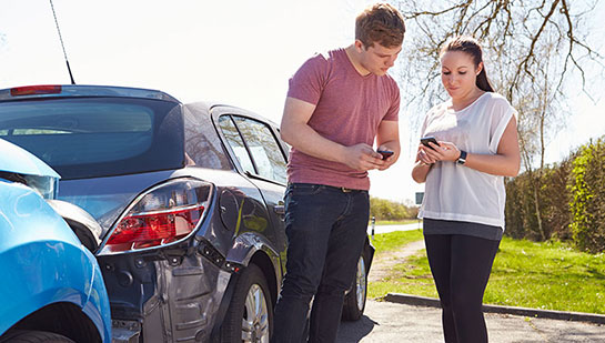 People exchanging information following an auto accident
