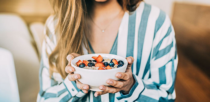 Woman eating a healthy cereal after receiving diet guidance from San Ramon chiropractor