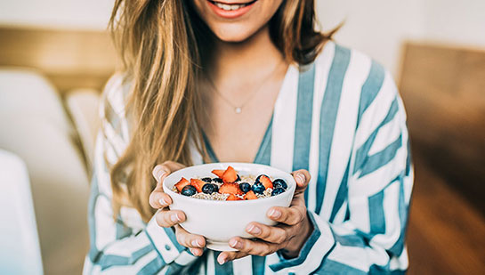 Woman eating a healthy cereal after receiving diet guidance from San Ramon chiropractor
