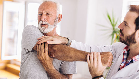 Elderly man receiving shoulder adjustment from San Ramon chiropractor