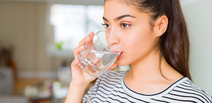 Woman drinking water to be healthy under the guidance of San Ramon chiropractor