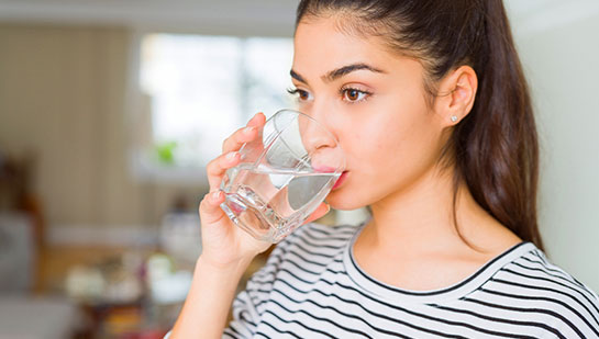 Woman drinking water to be healthy under the guidance of San Ramon chiropractor