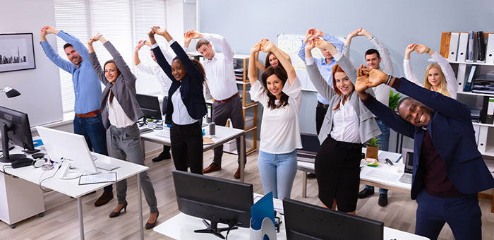 Office team stretching together under guidance of San Ramon chiropractor