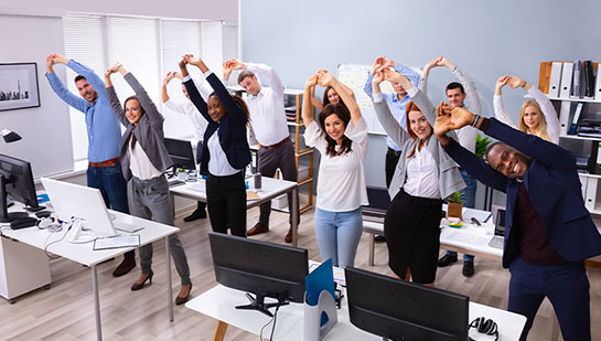 Office team stretching together under guidance of San Ramon chiropractor